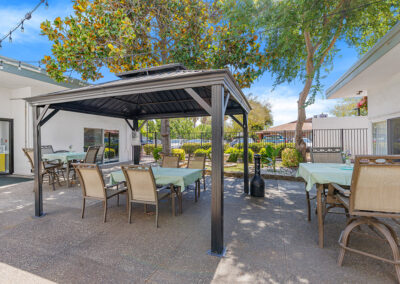 A gazebo with a table and chairs underneath in the courtyard of University Post Acute
